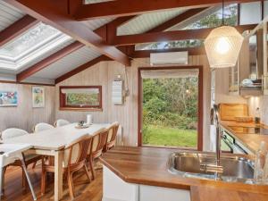 a kitchen and dining room with a table and a sink at 5 star holiday home in Nykøbing Sj in Nyrup +16 photos