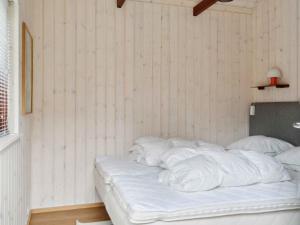an unmade bed with white sheets in a room at 5 star holiday home in Nykøbing Sj in Nyrup