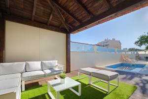 eine Terrasse mit einer Couch und einem Tisch und einem Pool in der Unterkunft Villa with Private Pool, BBQ & Patio in Vila Nova de Gaia