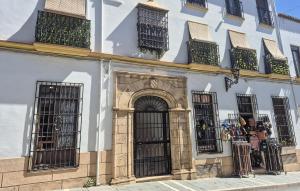 a building with barred windows and gates on it at Casa Del Arco in Ronda