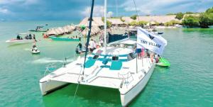 a sailboat docked in the water with people on it at Tiny Village Cartagena Boutique Resort in Tierra Bomba