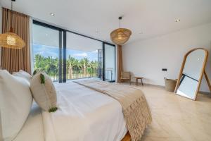a bedroom with a large bed and a large window at Townhouse T2 -Live Like a Local - Sophisticated Townhouse in Ubud in Ubud +7 photos