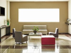 a living room with a couch and a table and chairs at Ibis Monterrey Valle in Monterrey