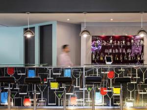 a man walking past a bar in a restaurant at Ibis Monterrey Valle in Monterrey +28 photos