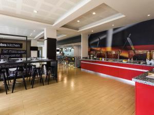 a restaurant with a bar and a counter with stools at Ibis Monterrey Valle in Monterrey
