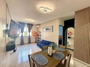 a living room with a table and a blue couch at Aluna Beach - Playa Miramar in Ciudad Madero