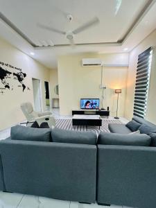 a living room with a blue couch and a tv at WanZa House in Bachok