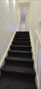 a stairway in a building with black stairs at Monteurs-Ferienwohnung in Emden