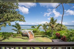 a view of the ocean from the balcony of a resort at The Emerald Surf House I home in Waialua