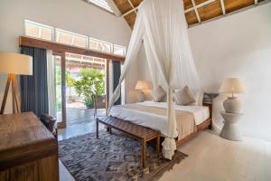 a bedroom with a bed with a mosquito net at Mowies On The Beach in Gili Air +54 photos