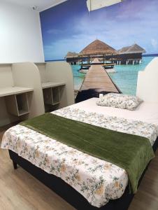 two beds in a room with a view of the ocean at Alojamento in Caxias do Sul