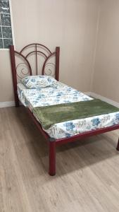 a bed in a room with a bedspread on it at Alojamento in Caxias do Sul