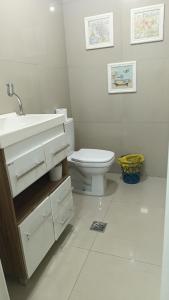 a bathroom with a white sink and a toilet at Alojamento in Caxias do Sul +21 photos