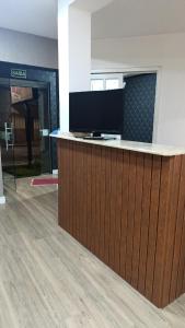 a lobby with a counter with a television on it at Alojamento in Caxias do Sul