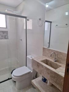 a bathroom with a sink and a toilet and a shower at Ap 440 m do mar, próx Beto Carrero in Navegantes +9 photos