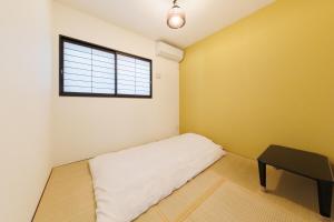 Habitación con cama con mesa y ventana en The Mansion 19 Modern Comfort with Serene Rice Field Views, en Inzai