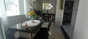 a dining room table with a vase of flowers on it at Ksl refúgio dos pássaros in Araquari