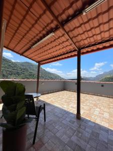a patio with a pergola with a table and a chair at Quase um Spa in Petrópolis