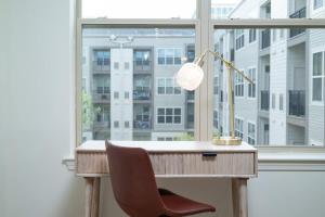 escritorio con lámpara y silla frente a una ventana en Lux 2BR w Gym Pool sleep 6 in Assembly Square, en Winter Hill