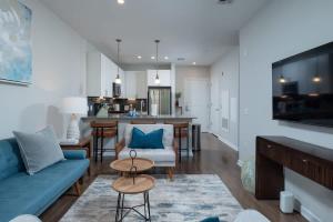 a living room with a blue couch and a table at Central 1-BR Condo Assembly Row Gym & Pool Sleep 5 in Winter Hill