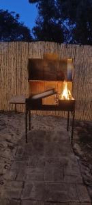 a bench with a fire on it in front of a fence at El refugio in La Paloma