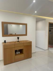 une salle de bain avec un lavabo et un miroir sur un mur dans l'établissement Vila Acácia 2, à Praia