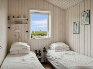 two beds in a room with a window at 5 star holiday home in Strøby in Strøby Ladeplads
