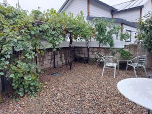 a patio with chairs and a table and trees at Gangneung Sandstay in Ŭmji-mal