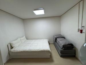 a small room with a bed and a window at Gangneung Sandstay in Ŭmji-mal