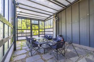 eine abgeschirmte Veranda mit einem Tisch und Stühlen in der Unterkunft Gapyeong FS Pool Villa in Oebang-ni + 2 Fotos