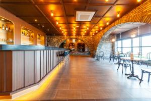 a bar in a restaurant with tables and chairs at Grand Hillstone Hotel in Jeonju