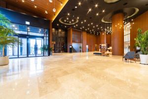 a large lobby with a large room with plants at Grand Hillstone Hotel in Hyoja-dong