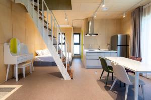 une chambre avec un lit et une cuisine avec un escalier dans l'établissement Gangneung Stayharam Villa, à Kyŏngp'o-mal