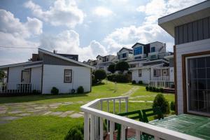 a balcony of a house with a yard with houses at Yiriro Stay in Kwangnyŏng-ni