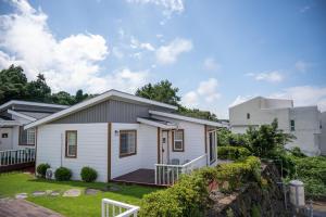 a small white house with a porch at Yiriro Stay in Kwangnyŏng-ni