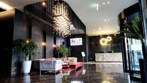 a lobby with a couch and chairs in a building at Golden Tulip Ever Yongin Hotel in Tugyeul