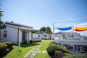 a house with two flags on the side of it at Yiriro Stay in Kwangnyŏng-ni +5 photos