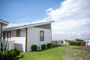 a small white house with a grass yard at Yiriro Stay in Kwangnyŏng-ni