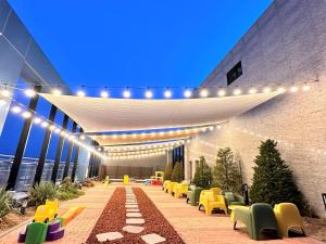 a lobby with yellow chairs and lights on a building at Golden Tulip Ever Yongin Hotel in Tugyeul
