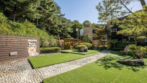a backyard with a garden with green grass at Glamdog Dog Pension Cheongpyeong Branch in Gapyeong