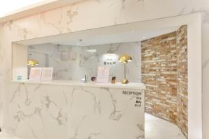 a room with a white marble wall and a mirror at Wonju Hotel Raum in Wonju