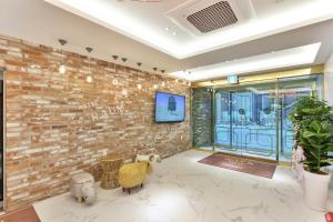 a lobby with a brick wall and a tv at Wonju Hotel Raum in Wonju