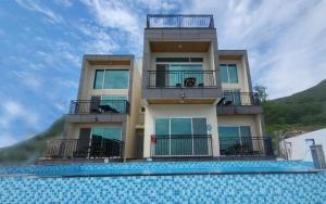 a building with a swimming pool in front of it at Geoje View Pension in Geoje 