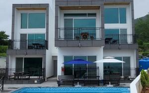 a apartment building with a swimming pool and two umbrellas at Geoje View Pension in Geoje 
