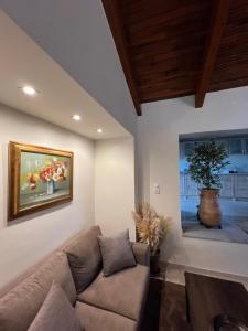 a living room with a couch and a painting on the wall at Entire Apartment 140m2 near Syvota and Parga in Makrochóra