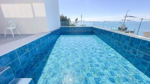 a swimming pool with blue tiles on a balcony at Yeosu Road 328 Ocean View Pool Villa in Yeosu