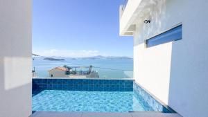 a swimming pool with a view of the ocean at Yeosu Road 328 Ocean View Pool Villa in P'yongsa-ri
