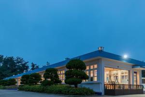 un bâtiment avec un arbre devant lui dans l'établissement Seosan Pet Glamping Pension Pet N Tree, à Ch'ŏngsal-li