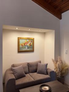 a living room with a couch and a painting on the wall at Entire Apartment 140m2 near Syvota and Parga in Makrochóra