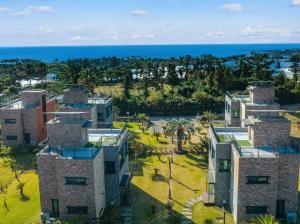 an aerial view of a building with the ocean in the background at Seogwipo Jaybrooder in Sinhŭng il-li